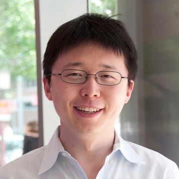 Bust shot of Feng Zhang (Chinese man with short black hair and glasses, wearing a white collared shirt), smiling at the camera